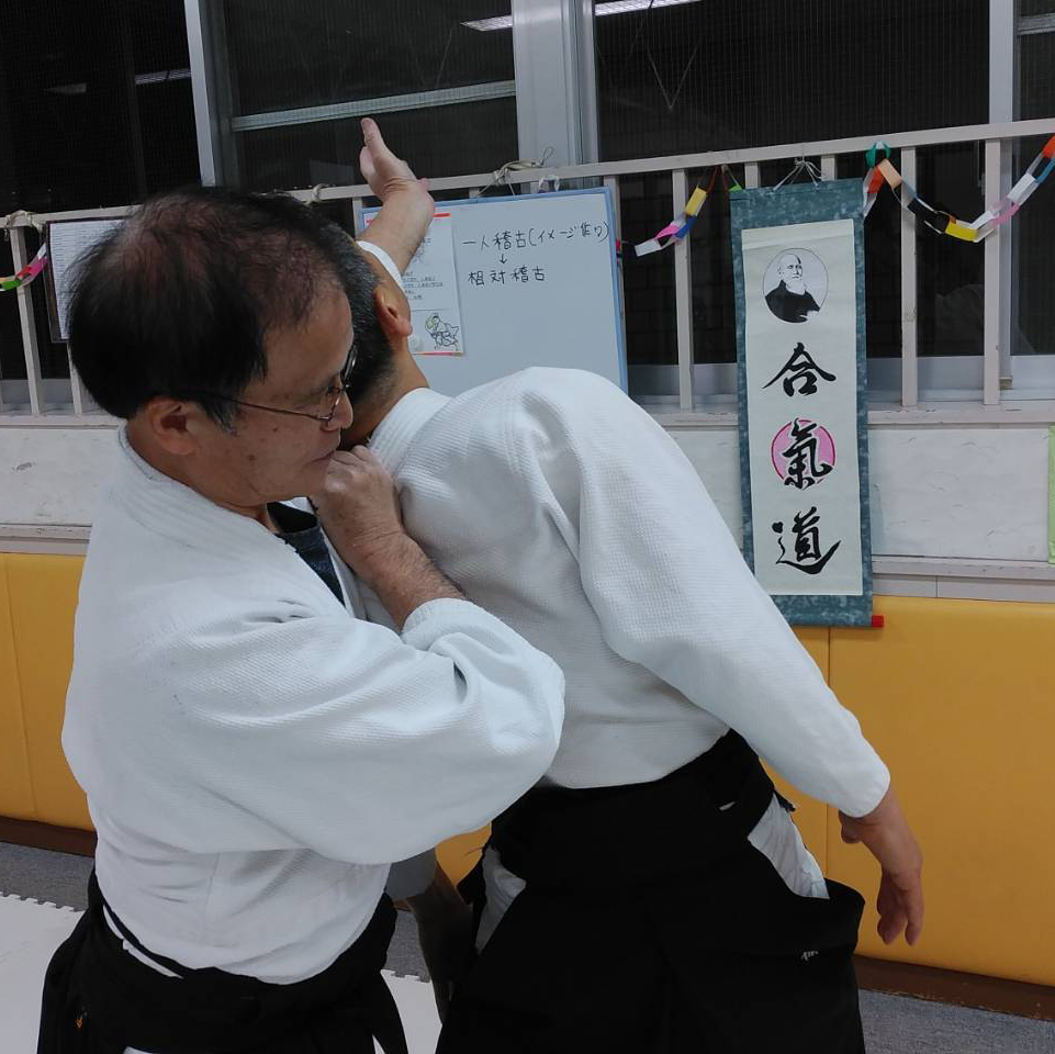 二人で組み、合気道の技を稽古している様子