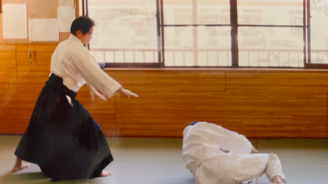 畳の上で、二人一組で合気道の技を稽古する様子